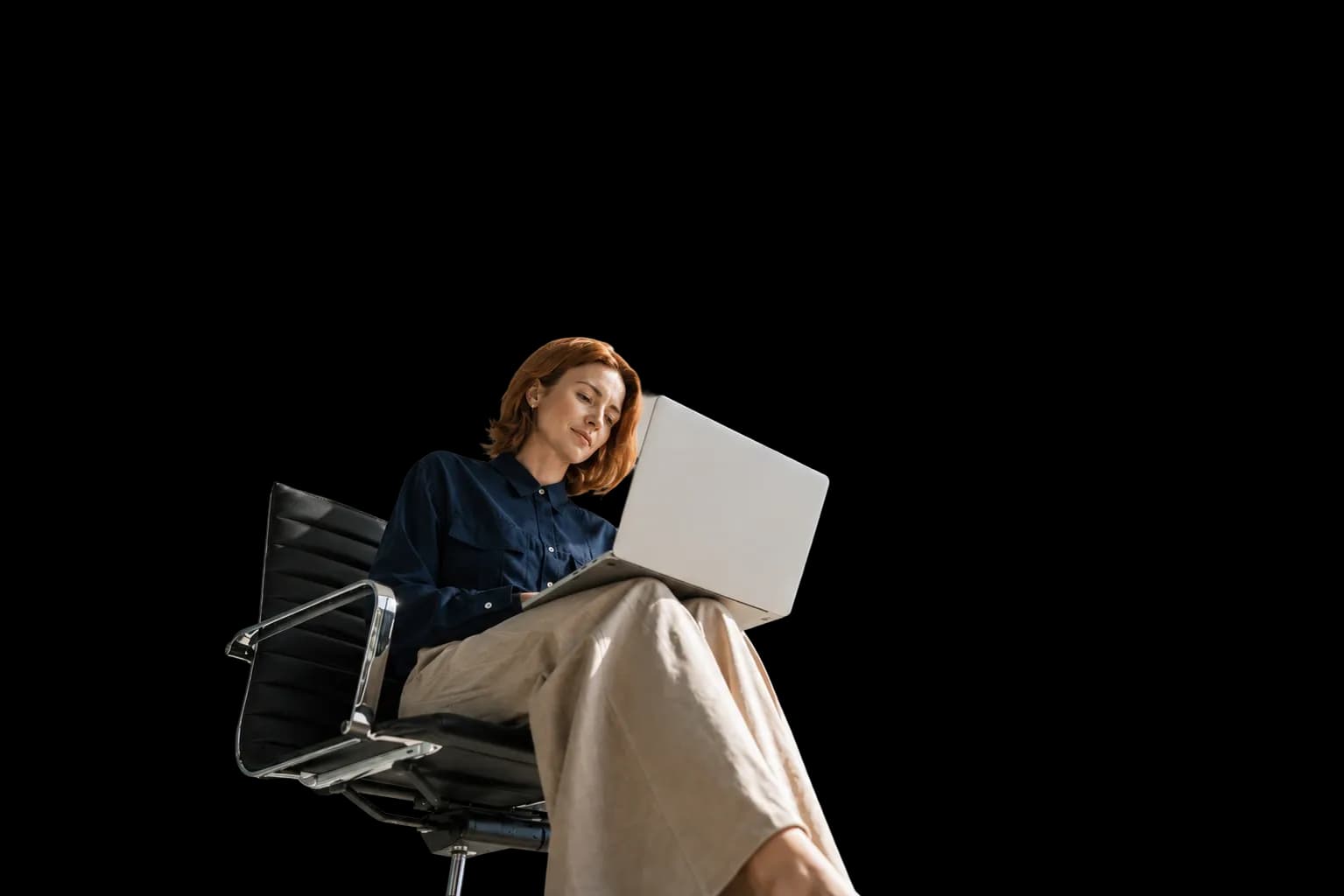 Mulher sentada em uma cadeira de escritório, trabalhando em um notebook